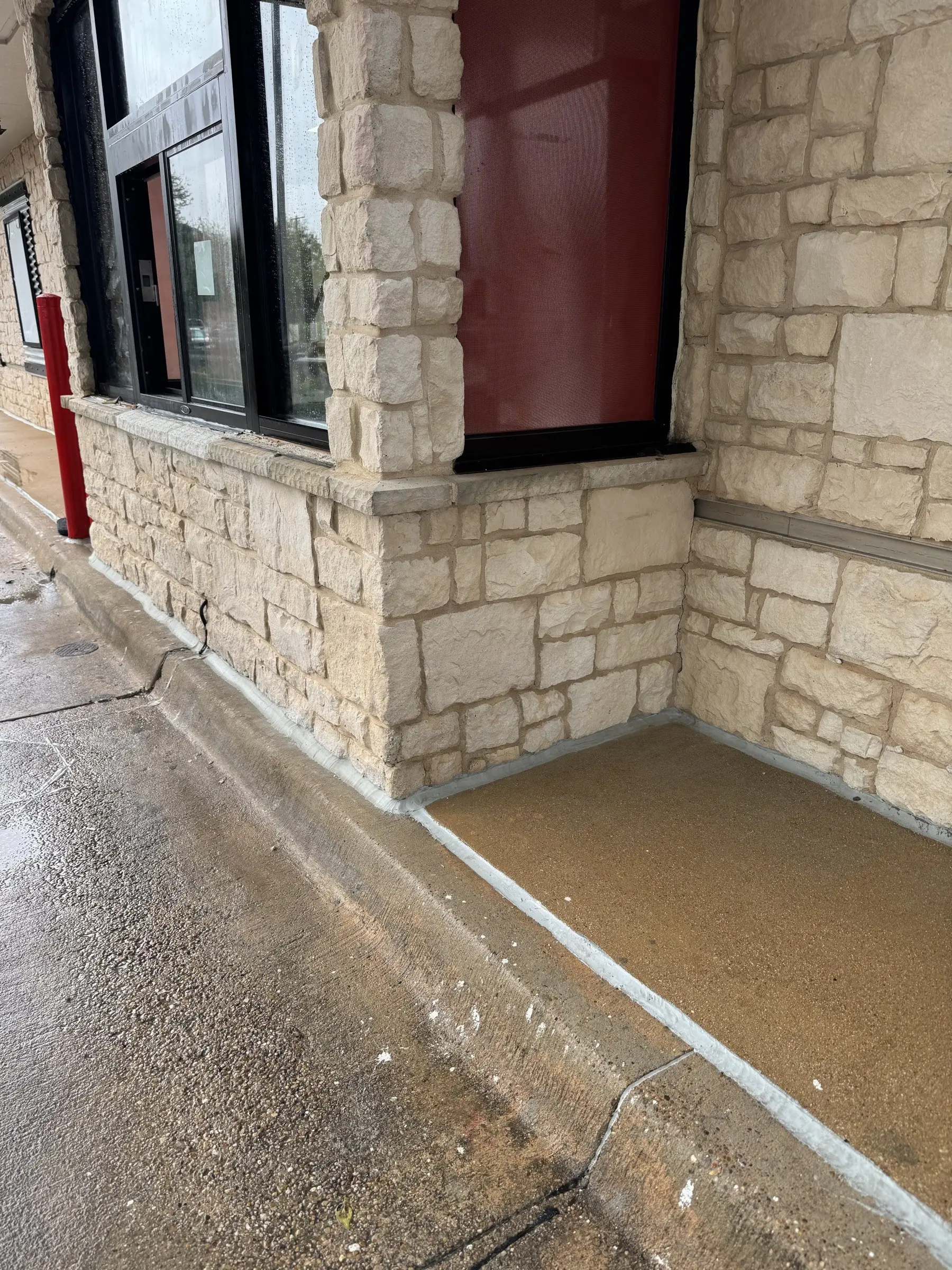 The same limestone corner after cleaning, the stone an even pale color and the exposed aggregate apron bright and clear